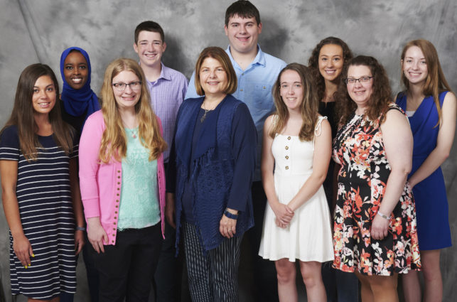 Nine college students posing with scholarship fund donor