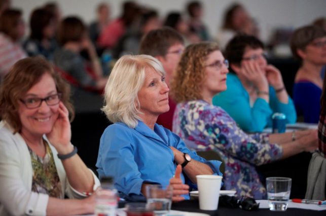 A section of a crowd facing the same direction and listening.