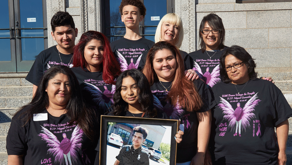 A group of family and friends holds a photo of their deceased loved one on the Capitol steps.