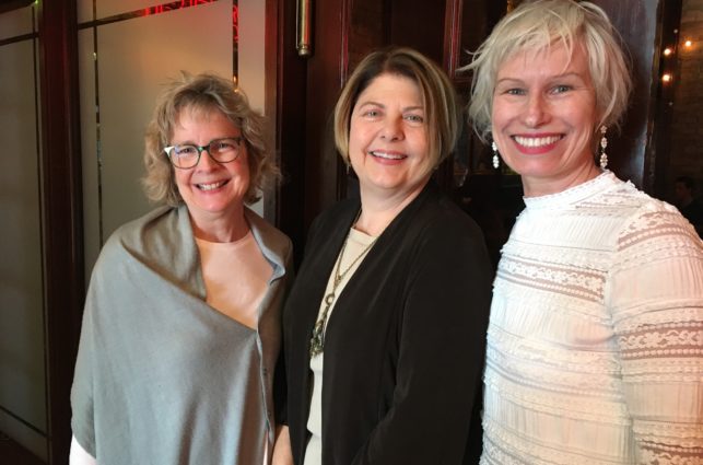 Three people, the founders of the epilepsy art showcase, standing together and smiling.