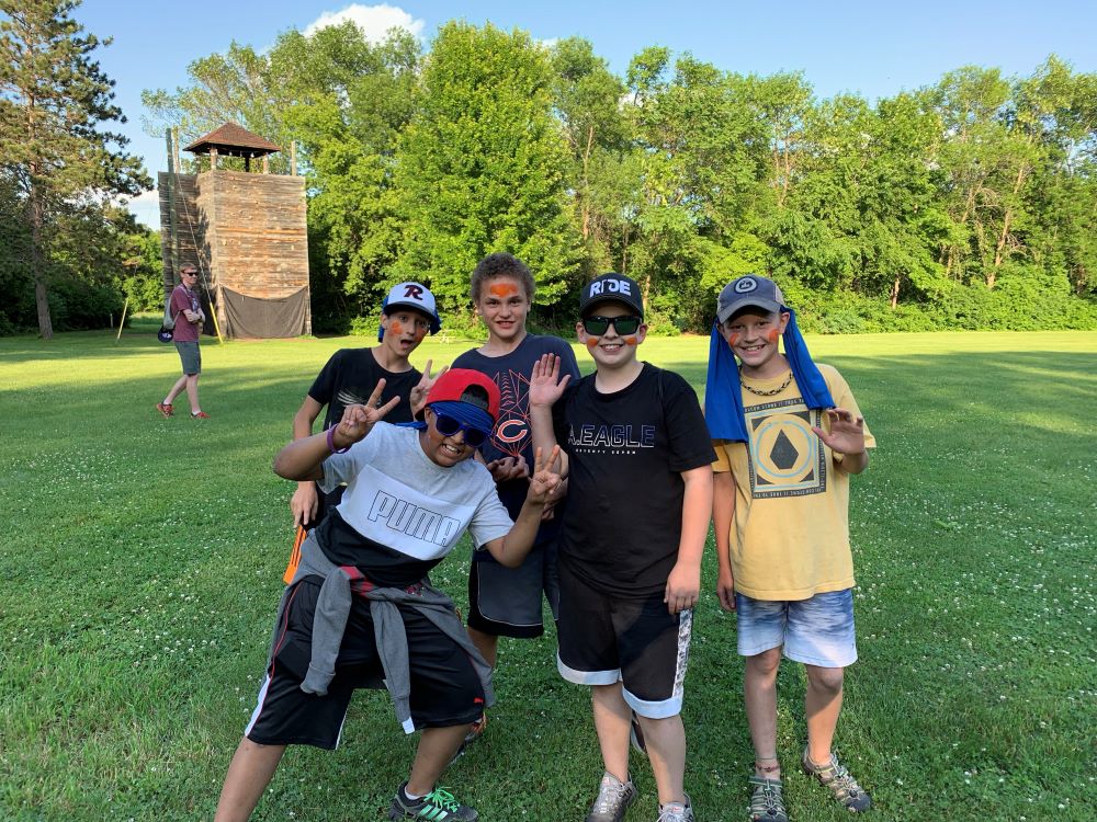 A group of young campers in hats pose for the camera