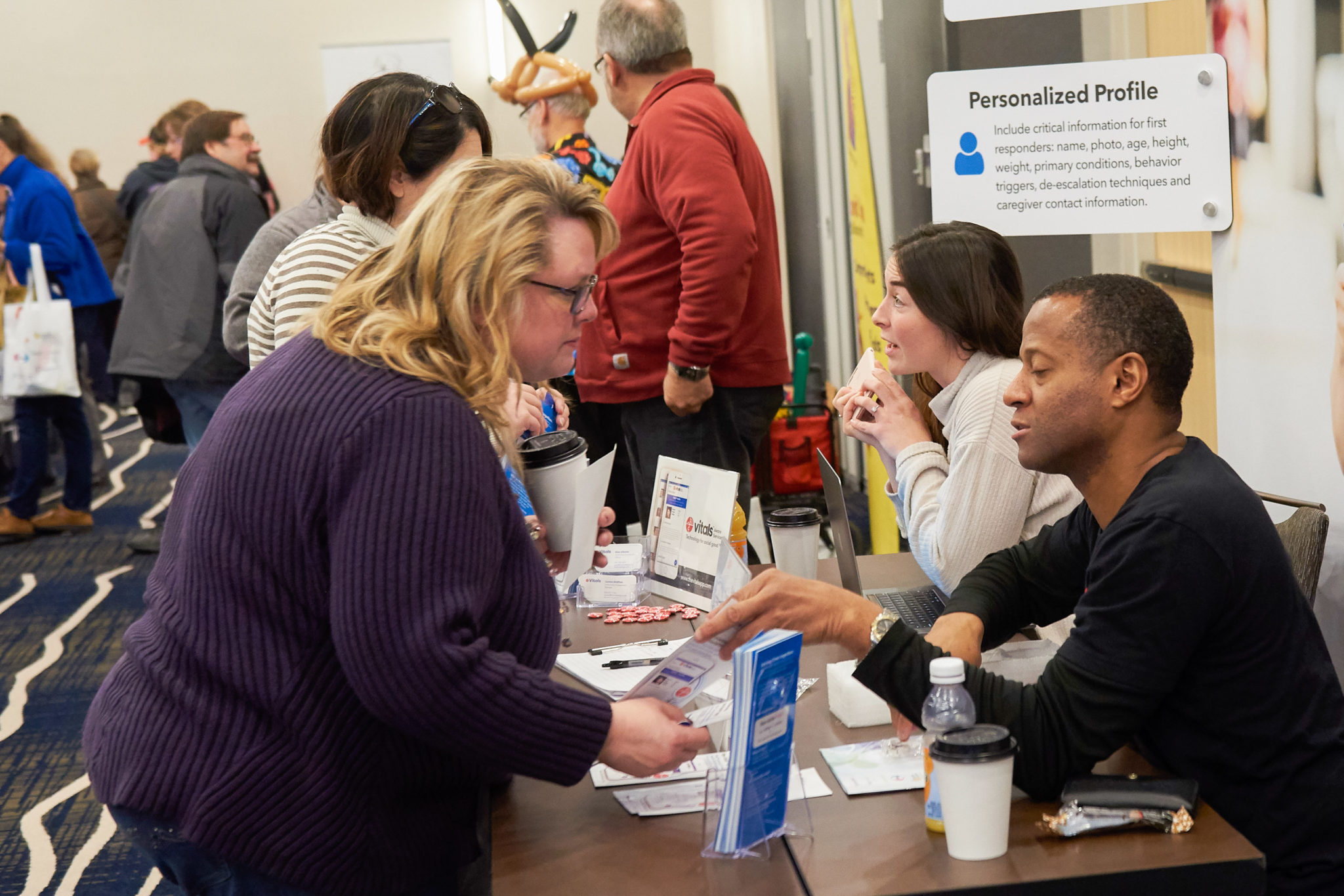 Adult male is handing a brochure to an adult woman while talking