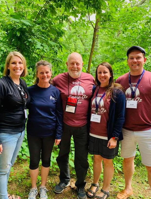 A group of five camp staff smiling outdoors