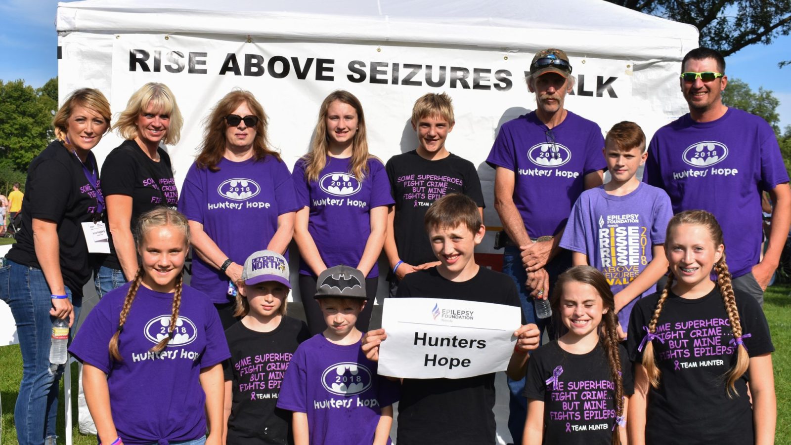 Group of 14 people of all ages smiling at Rise Above Seizures Walk