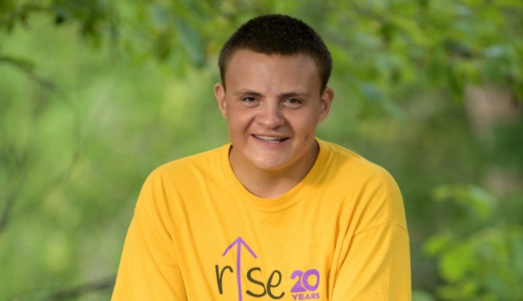 15 year old male smiling with woods background