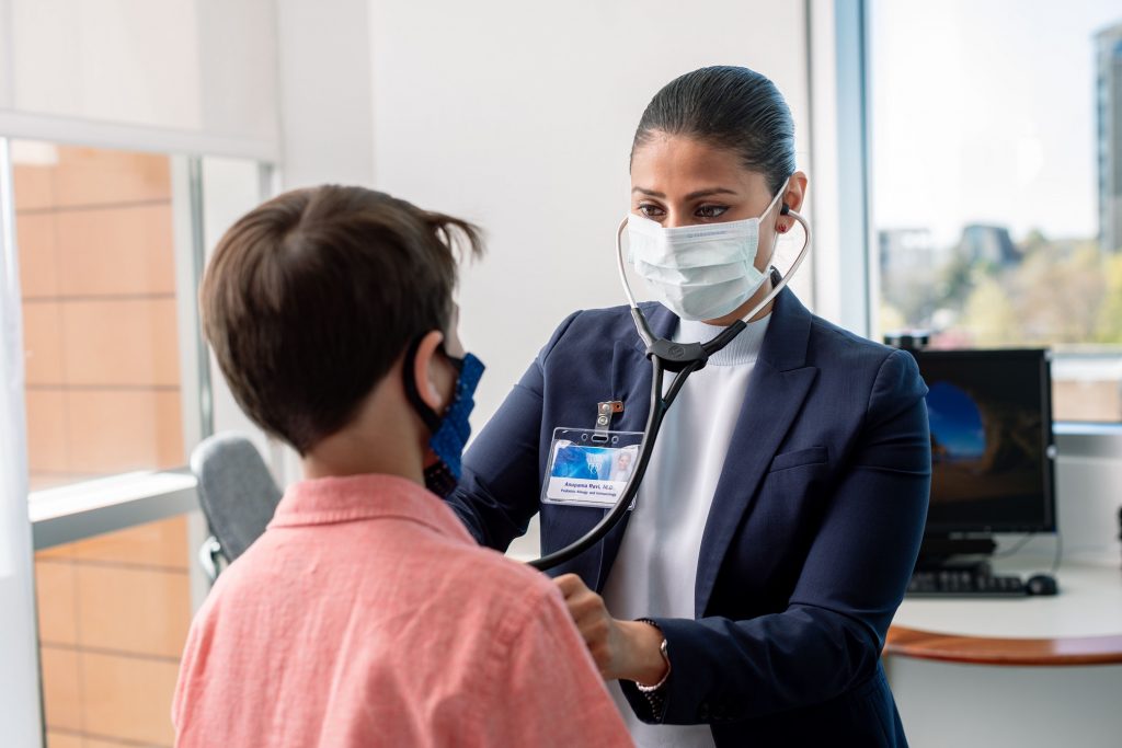 doctor with stethoscope treats young child