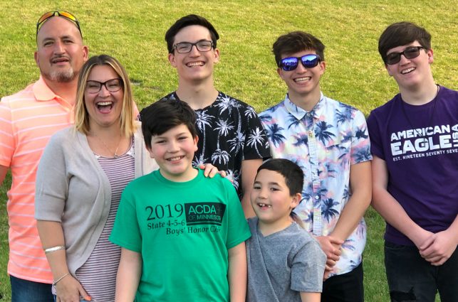 Two adult parents with their five kids all boys