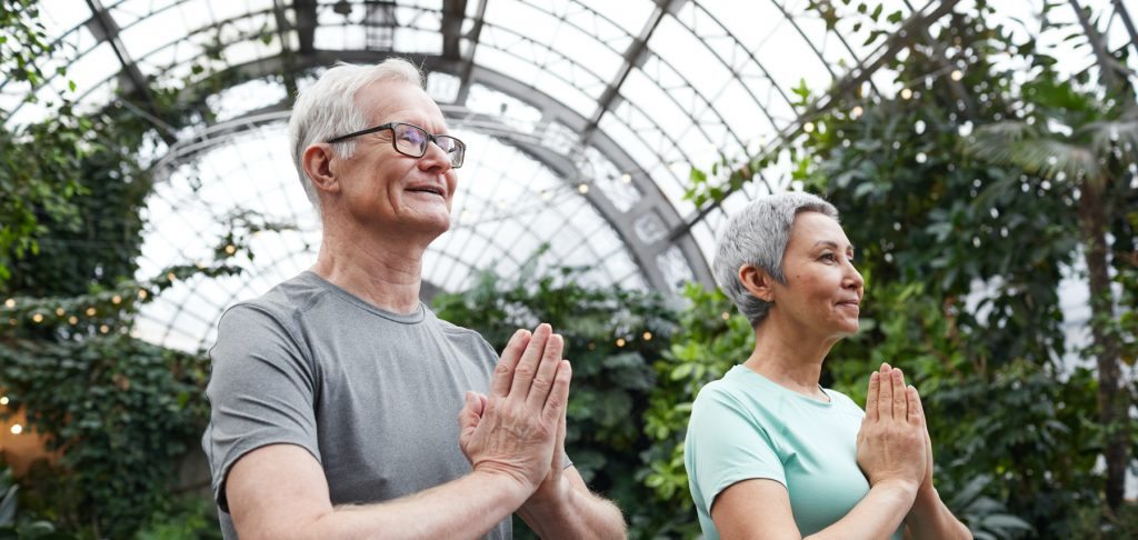 white hair man and woman meditating