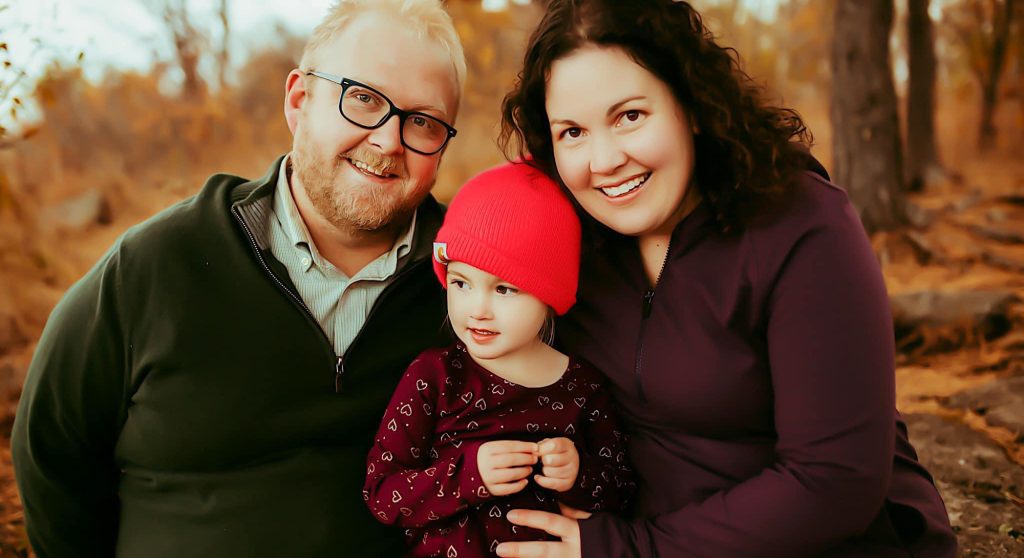 woman and husband with young child outdoors