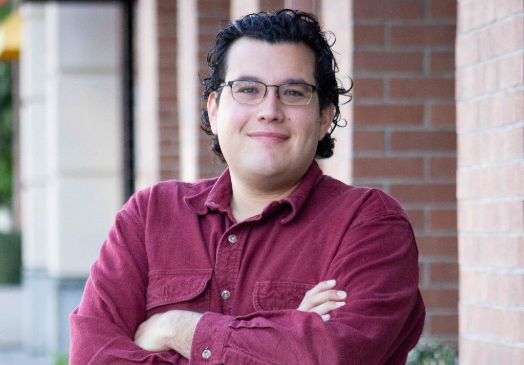 man smiling and camera arms crossed