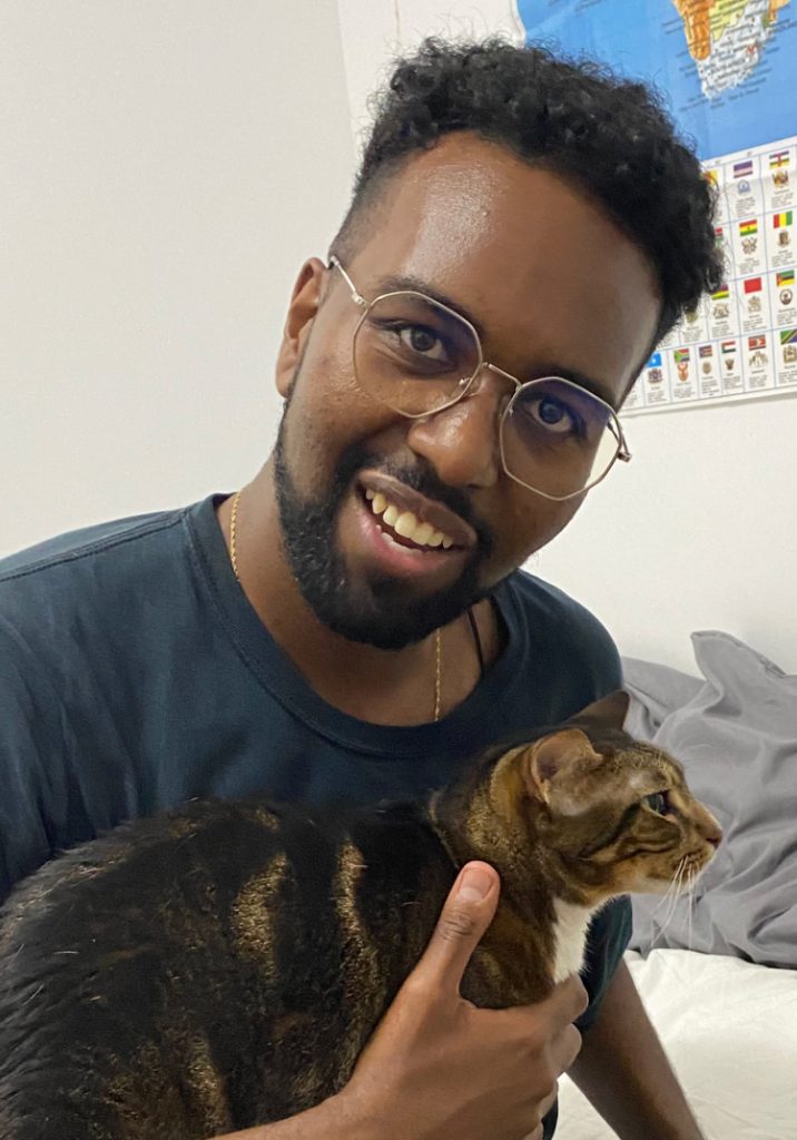 yafiet holding his cat and smiling
