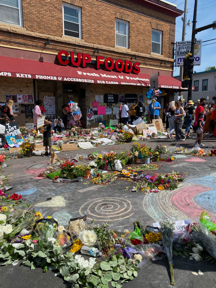 Outdoor memorial with people and flowers