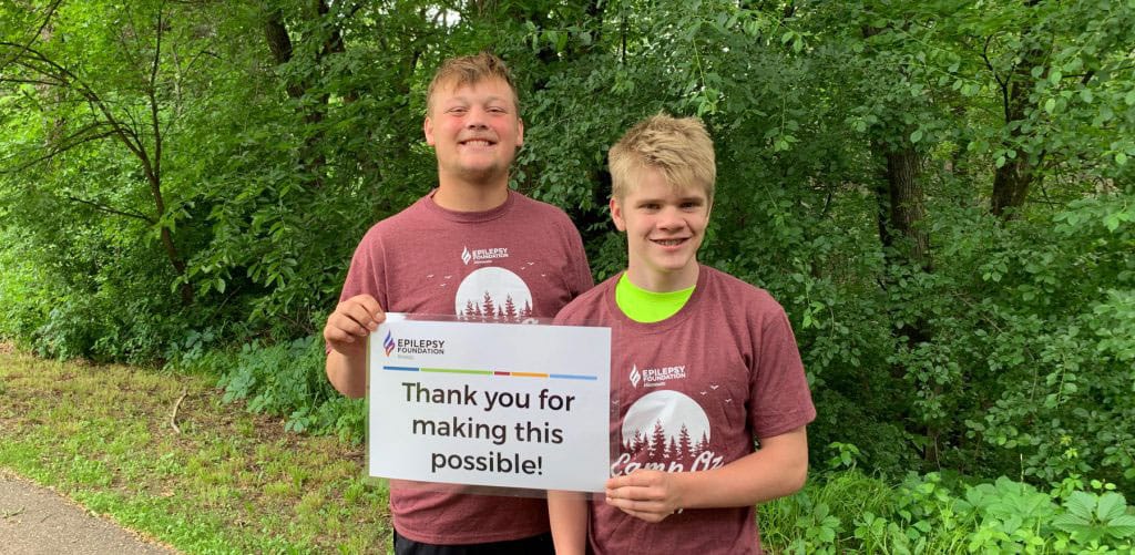 Two boys holding a sign that says Thank You