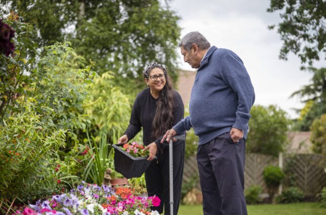 Two aging adults interacting in a garden