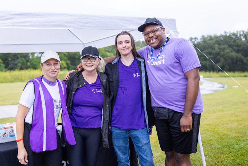 Outreach manager Lisa Necastro with Moorhead EFMN community members wearing purple