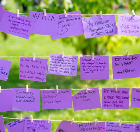 Purple notes clipped on yarn sharing stories about their "why"