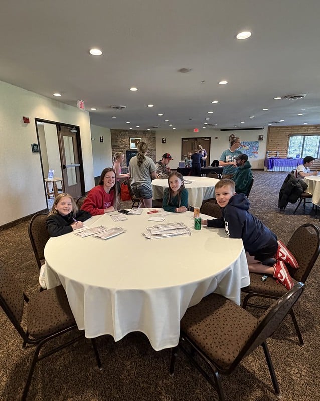 Attendees pose for a photo at the event while socializing at a table